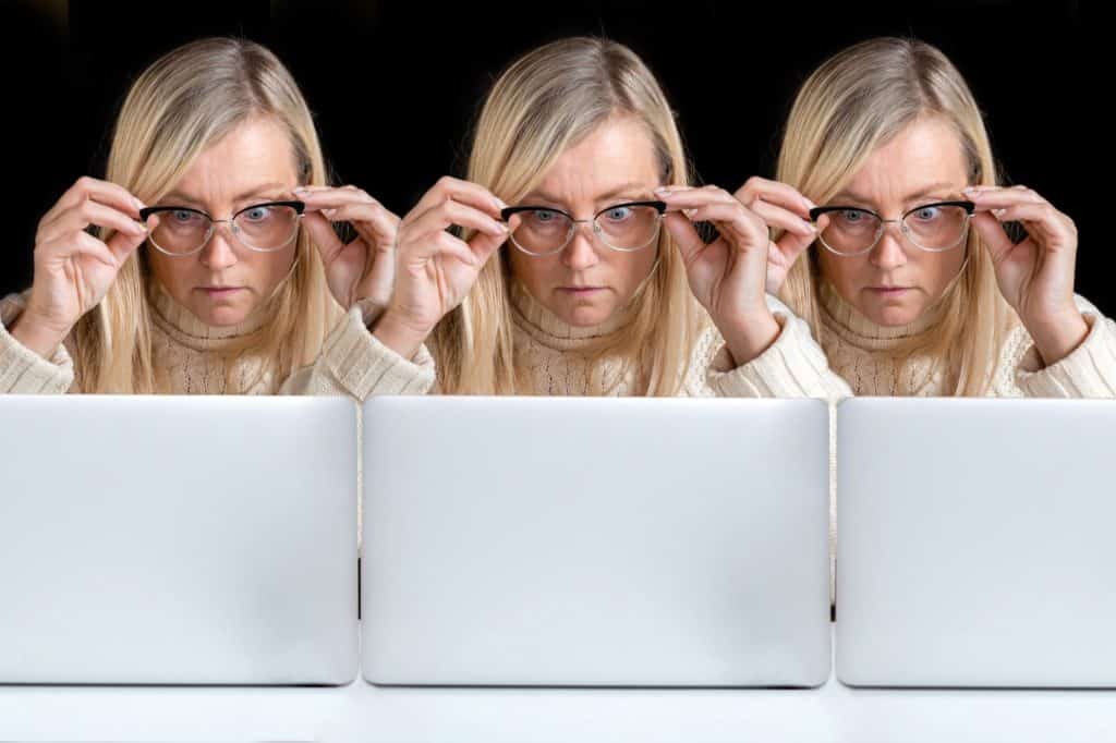 cloned image, three identical, emotional middle-aged women surprised staring at a computer screen